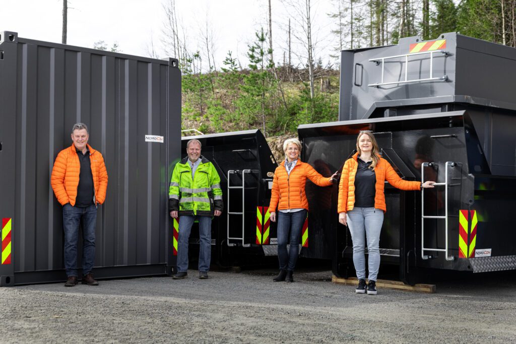 Jørn, Lars, Marit og Trine foran svarte containere