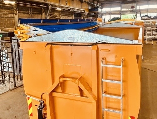 Lettvektskornkasse med hydraulisk Asfalt MAXI-kapell i sammenfoldet posisjon. Bildet viser kapellet lagret foran på kassen og åpen tilgang til lasteområdet.